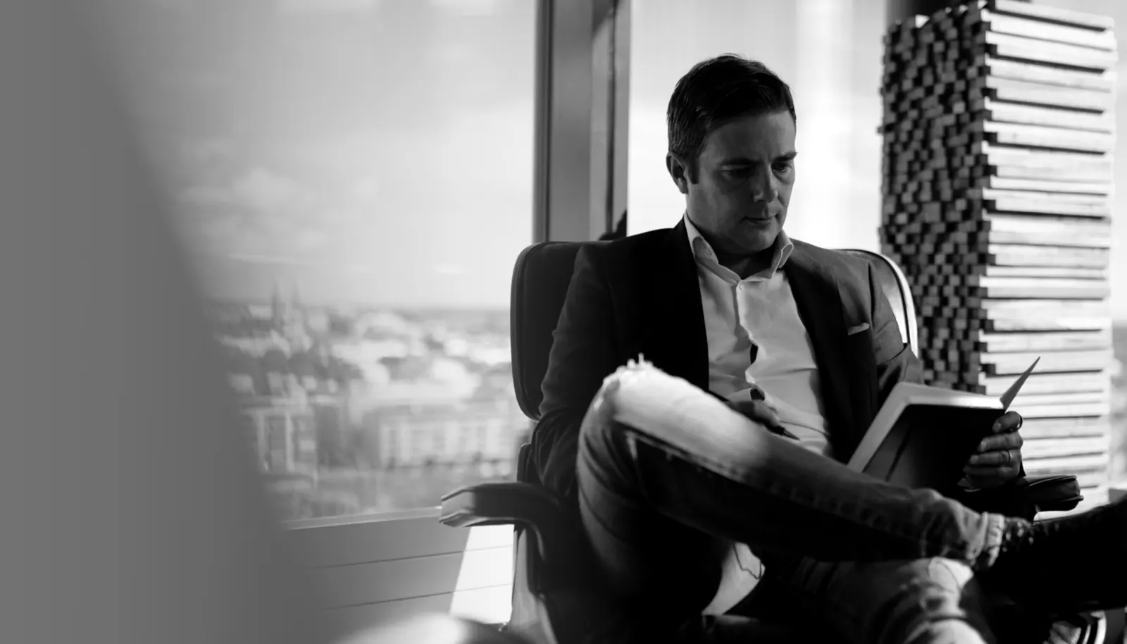 Jukka Blomberg working by a window overlooking Helsinki